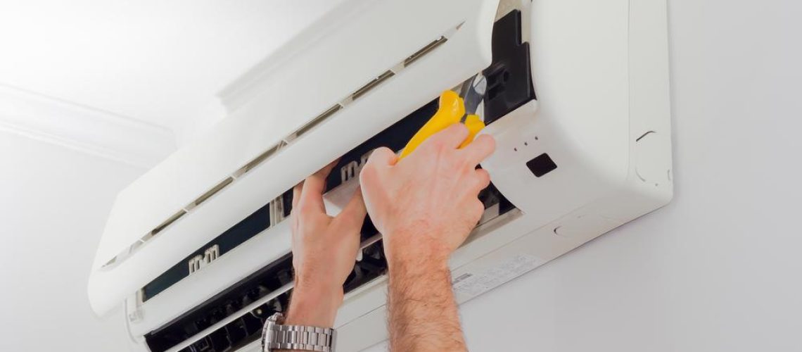 Reaching to start cleaning the filter on an Air Condition